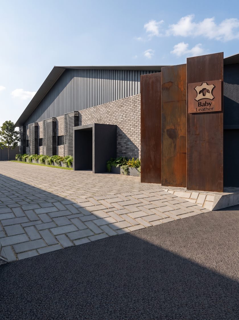 Entrada da reforma Baby Leather, com totens de aço corten e fachada em tijolo aparente e brises metálicos